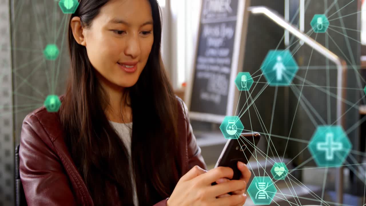 Animation of two globes of medical icons spinning over asian woman using smartphone at a cafe