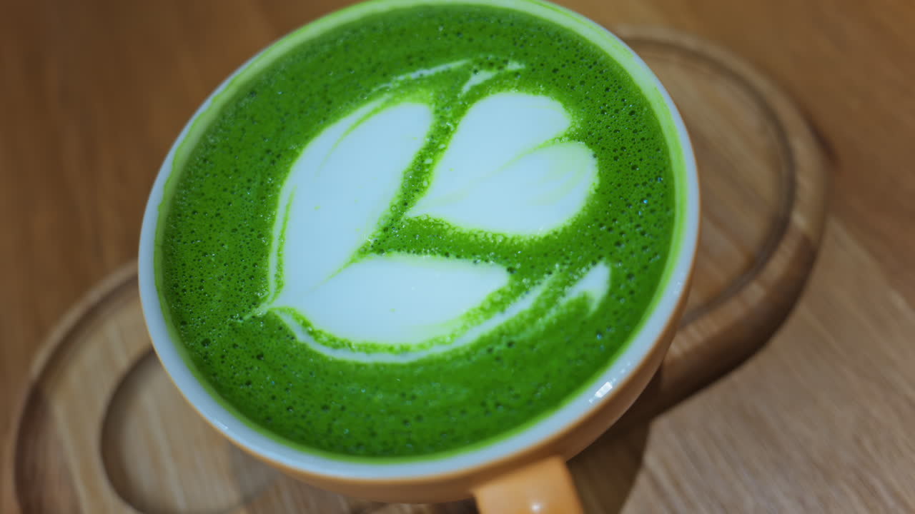 Close up of a matcha latte on a wooden tray at a cafe
