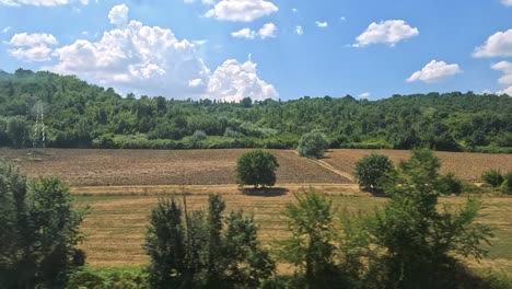 scenic fields and hills from a moving train