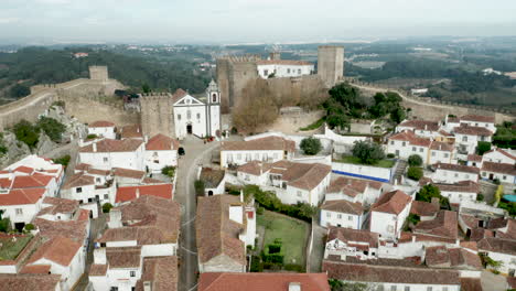 ciudad dentro de las murallas del castillo en obidos portugal durante el día - ascenso aéreo