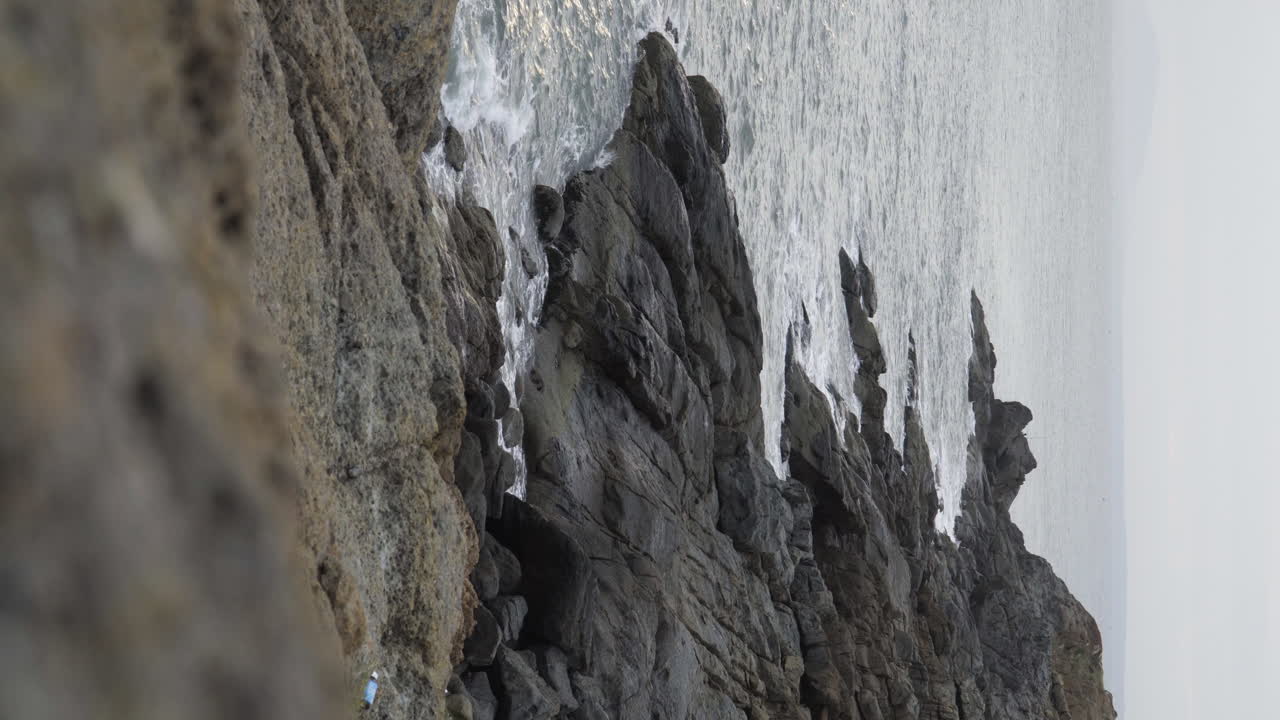 파도가 베트남 수직 샷에서 무이네 반도의 바위 해안을 강타했습니다.