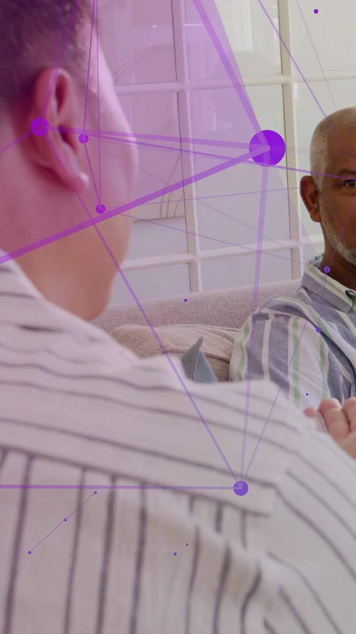 Vertical video: Man gesturing while cam pulling back, revealing couch chat with purple tech overlay