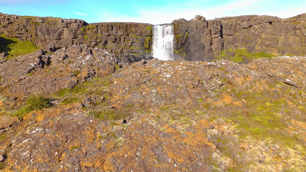 Aerial shot reveals beautiful &Ouml;xar&aacute;rfoss waterfall as &Ouml;xar&aacute; River as plunges gracefully into a chasm of rugged rock formations