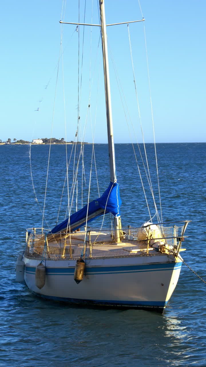 White and blue boat docked with the blue sky on the background. Vertical in France
