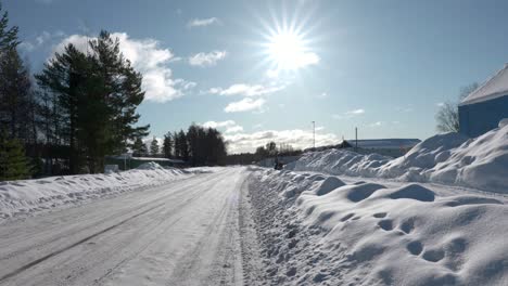 a group of snowmobiles driving on the side of the road, on cold sunny winter day in sweden