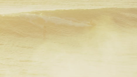 surfer flying along wave at nazare beach in portugal