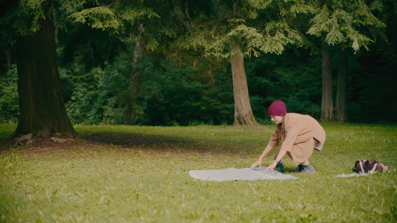 공원 의 잔디 에 담요 를 고 있는 여자