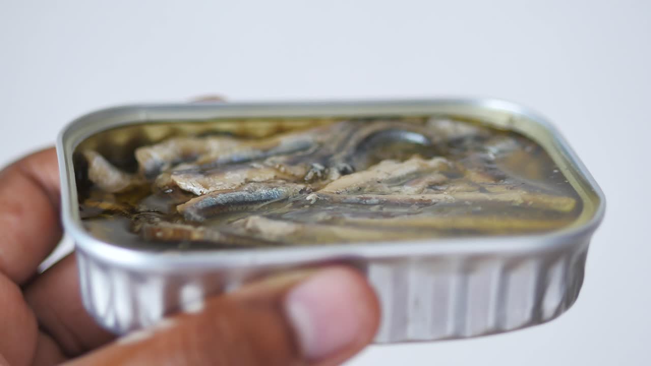 사르디네 캔 을 들고 있는 손
