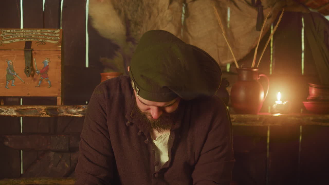 бородатый бармен саркастично смотрит на гостей в таверне. карлик-слуга выражает недоверие к кредитоспособности клиентов в средневековой гостинице. рутина гостевого дома