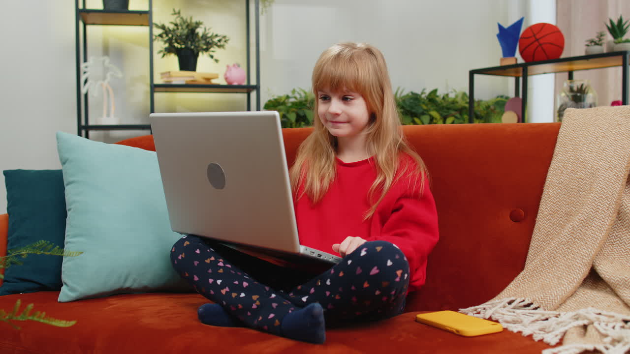 Preteen child girl looking at laptop camera making video webcam conference call with friends family