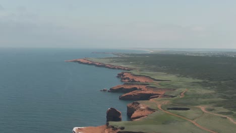 stunning landscape of magdalen islands with lush green fields and forest by the gulf of saint lawrence in northern quebec, canada