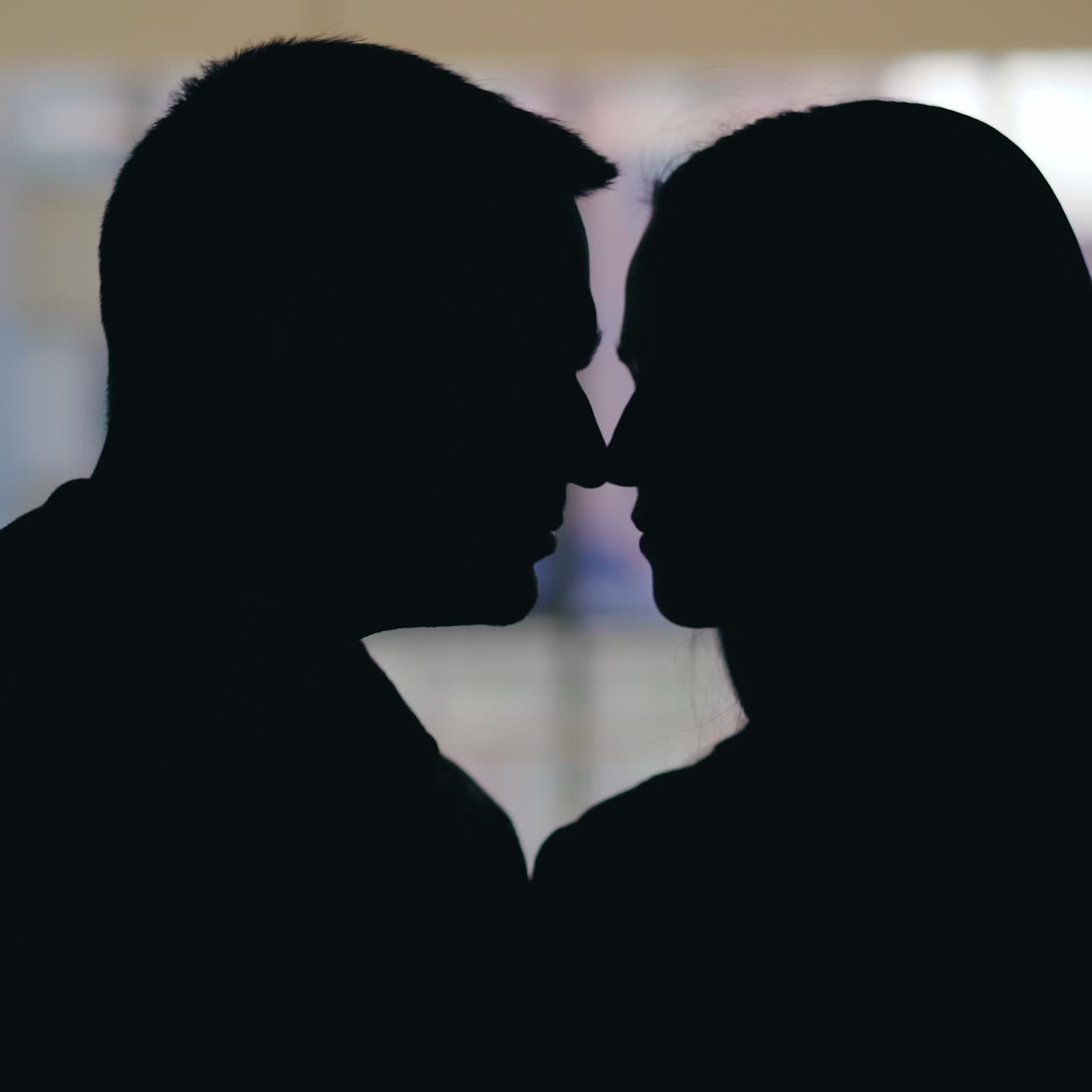 Enamored ?ouple are flirting in the restaurant on the background of the window. Silhouette of man and woman. Date in the cafe.