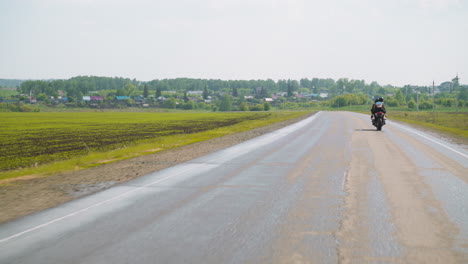 Frau-Mit-Freund-Fährt-Motorrad-Entlang-Ackerland