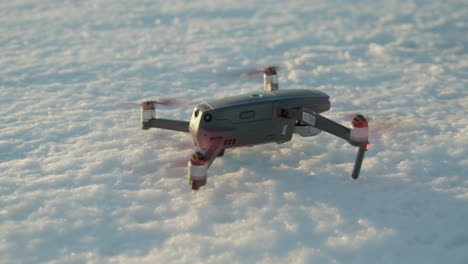hélices de drones girando mientras están parados en suelo congelado a la hora dorada