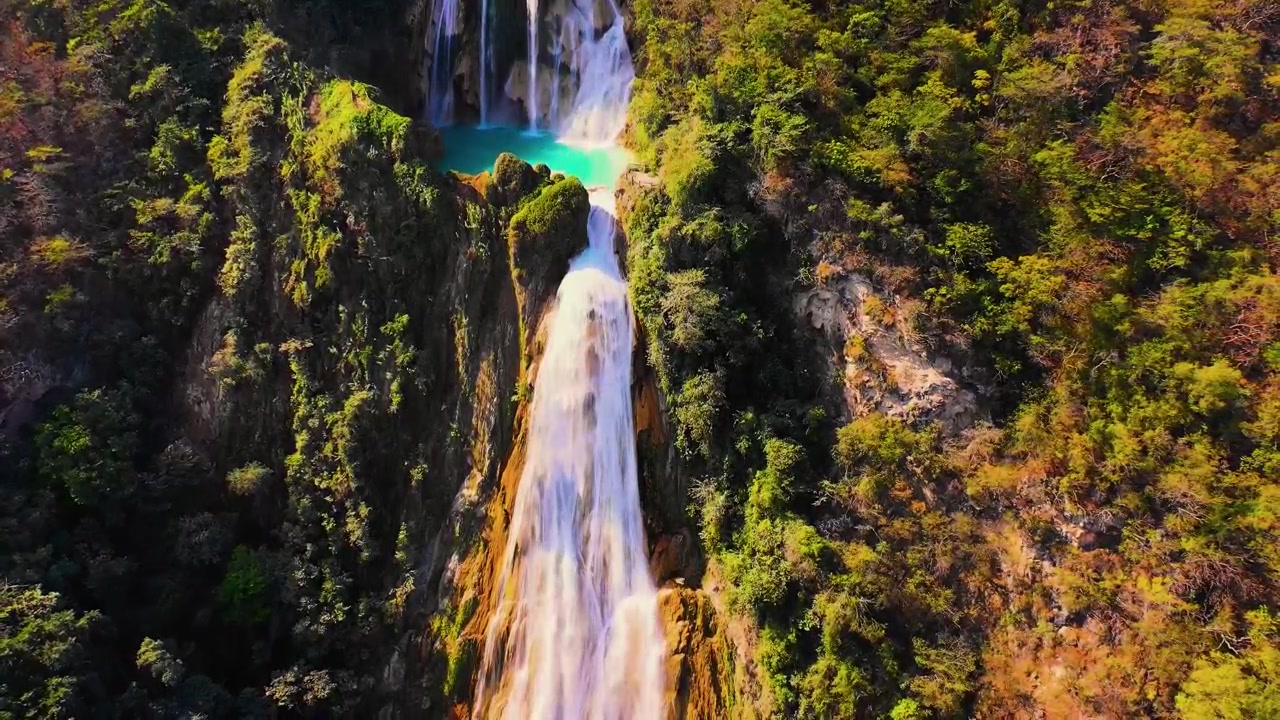 Una mozzafiato ripresa aerea verticale cinematografica da drone che cattura le maestose cascate a più livelli di El Chiflón che si gettano in vivaci piscine turchesi in mezzo a una fitta e rigogliosa chioma della giungla del Chiapas.