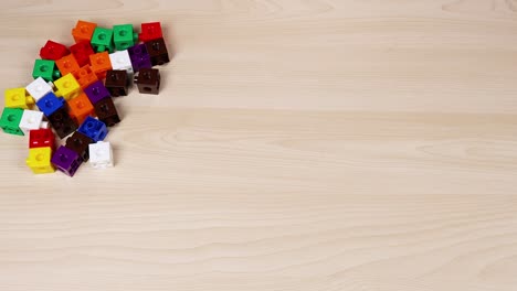 hands assembling colorful linking cubes on table