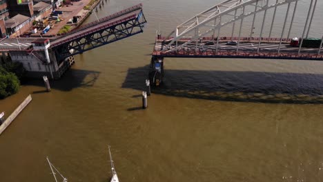 Vista-Aérea-De-Veleros-Esperando-Que-Se-Abra-El-Puente-Basculante-De-Una-Sola-Hoja-Para-La-Autorización-De-Paso-En-Alblasserdam,-Países-Bajos