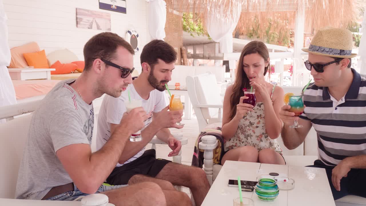 amigos disfrutando de bebidas en un café de la playa
