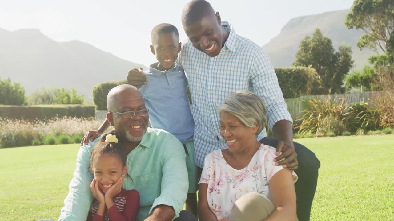 Video of happy african american family spending time together in the garden