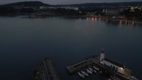 establishing night drone shot of scarborough lighthouse and town