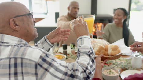 African-american-parents,-children-and-grandparents-celebrating-at-thanksgiving-dinner,-slow-motion