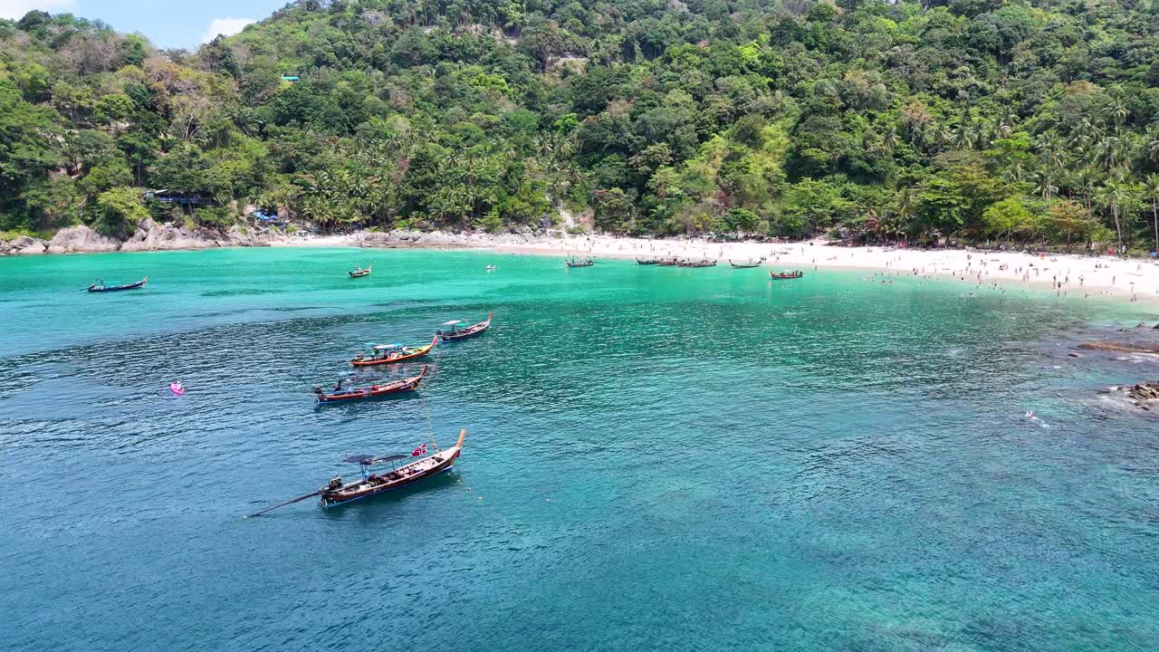 vista aérea de una bulliciosa playa de phuket con barcos, nadadores y vegetación exuberante bajo la brillante luz del sol