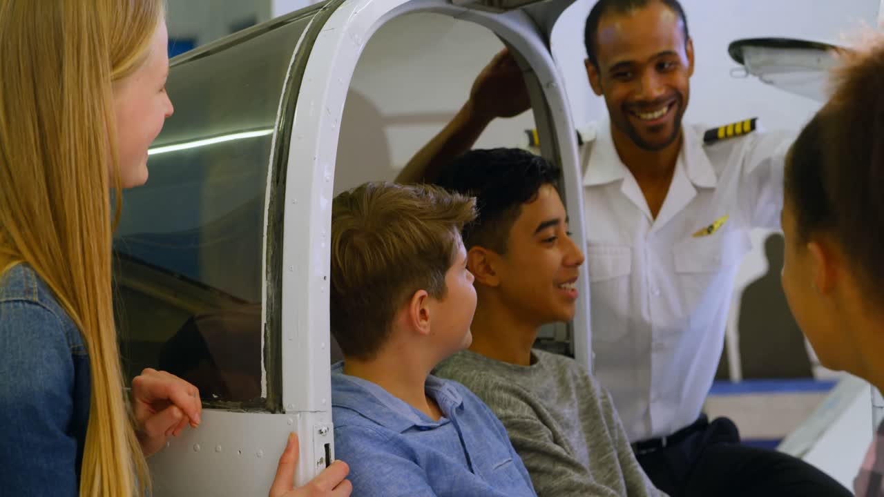 piloto masculino explicando sobre el avión a los niños 4k
