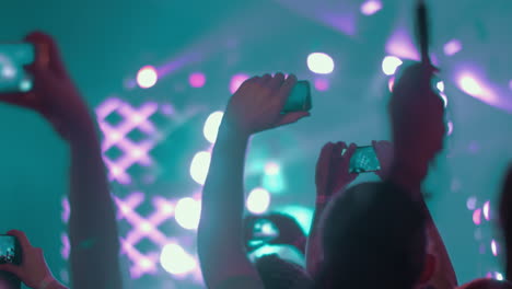 fanáticos de la música haciendo videos con células en el concierto