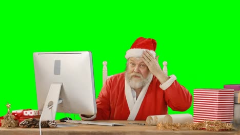 Santa-claus-talking-while-working-on-personal-computer