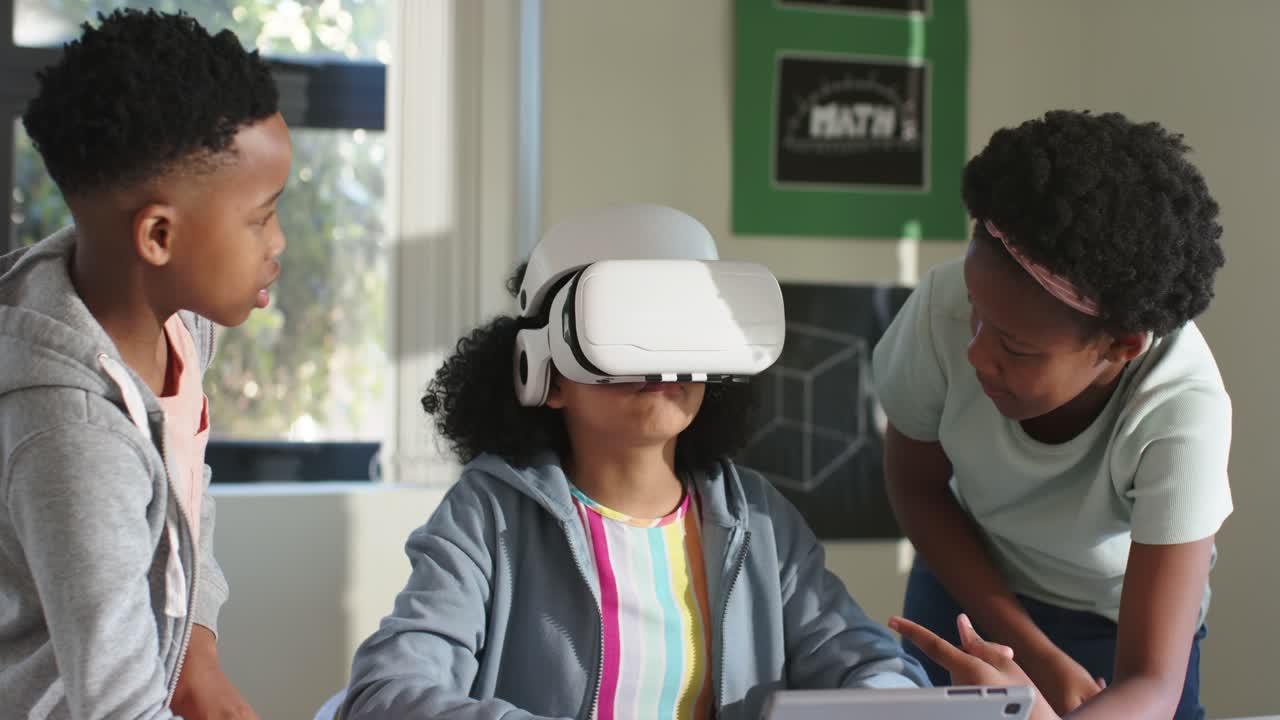 Afrikansk-amerikanske teenagere læner sig frem og peger på en tablet, mens en kvinde med VR-headset lærer i klassen