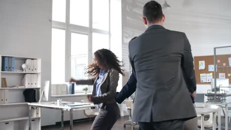 emocionado equipo de negocios bailando conga en la oficina