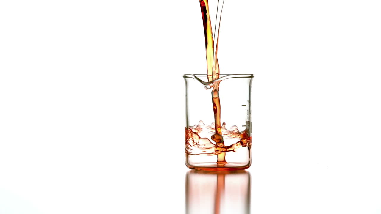 오렌지 액체가 유리 컵에 아집니다.