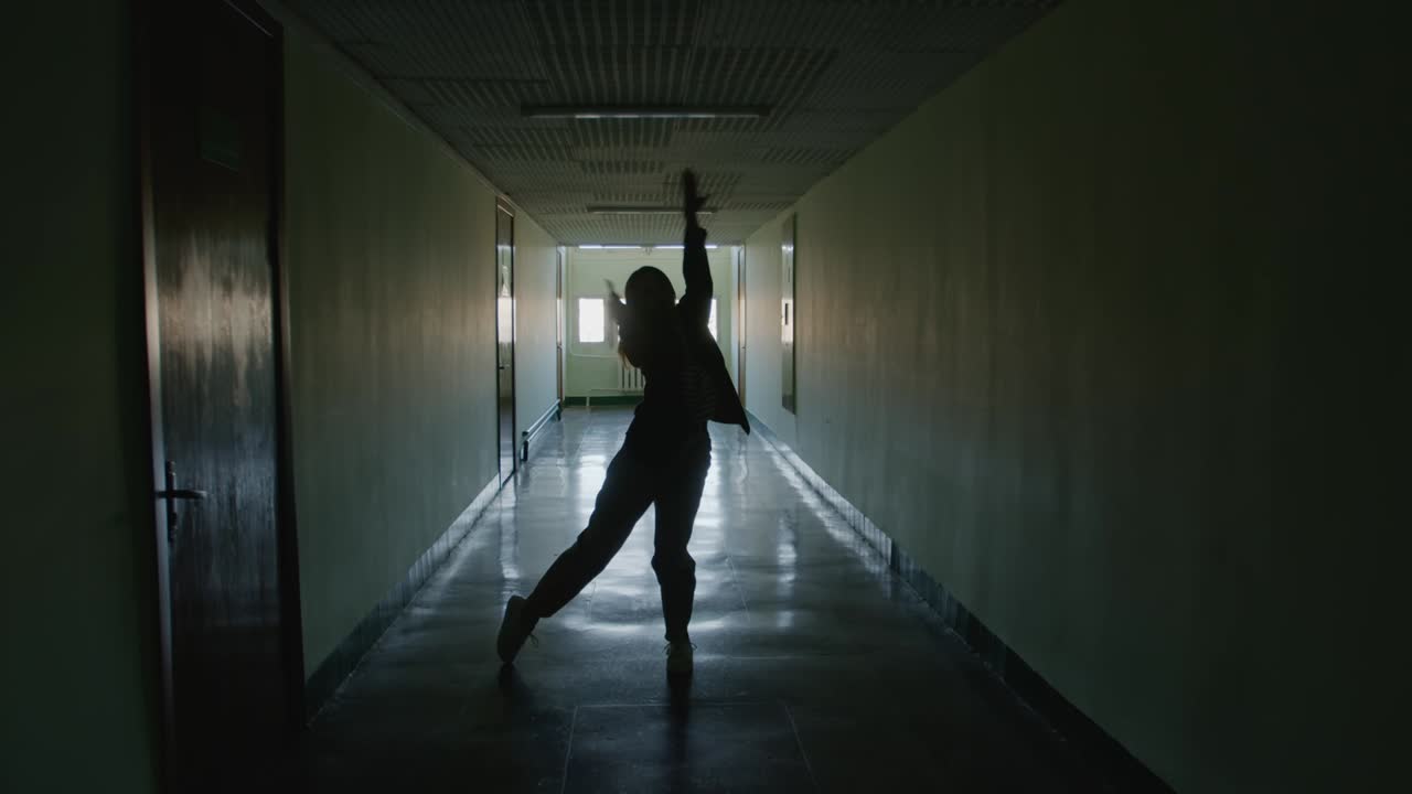 silueta femenina bailando el desprecio en el pasillo