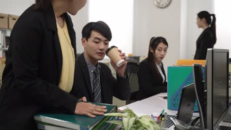 slow motion of man employee getting more heavy workload from manager while he is taking coffee break in the office. a coworker doing nothing but showing him a cheer gesture