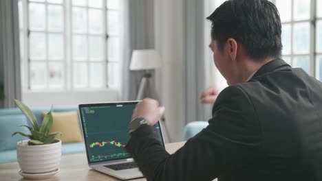 Asian Businessman Wearing Business Suit Being Happy After Seeing Uptrend In The Trading On Computer Screen While Working At Home.