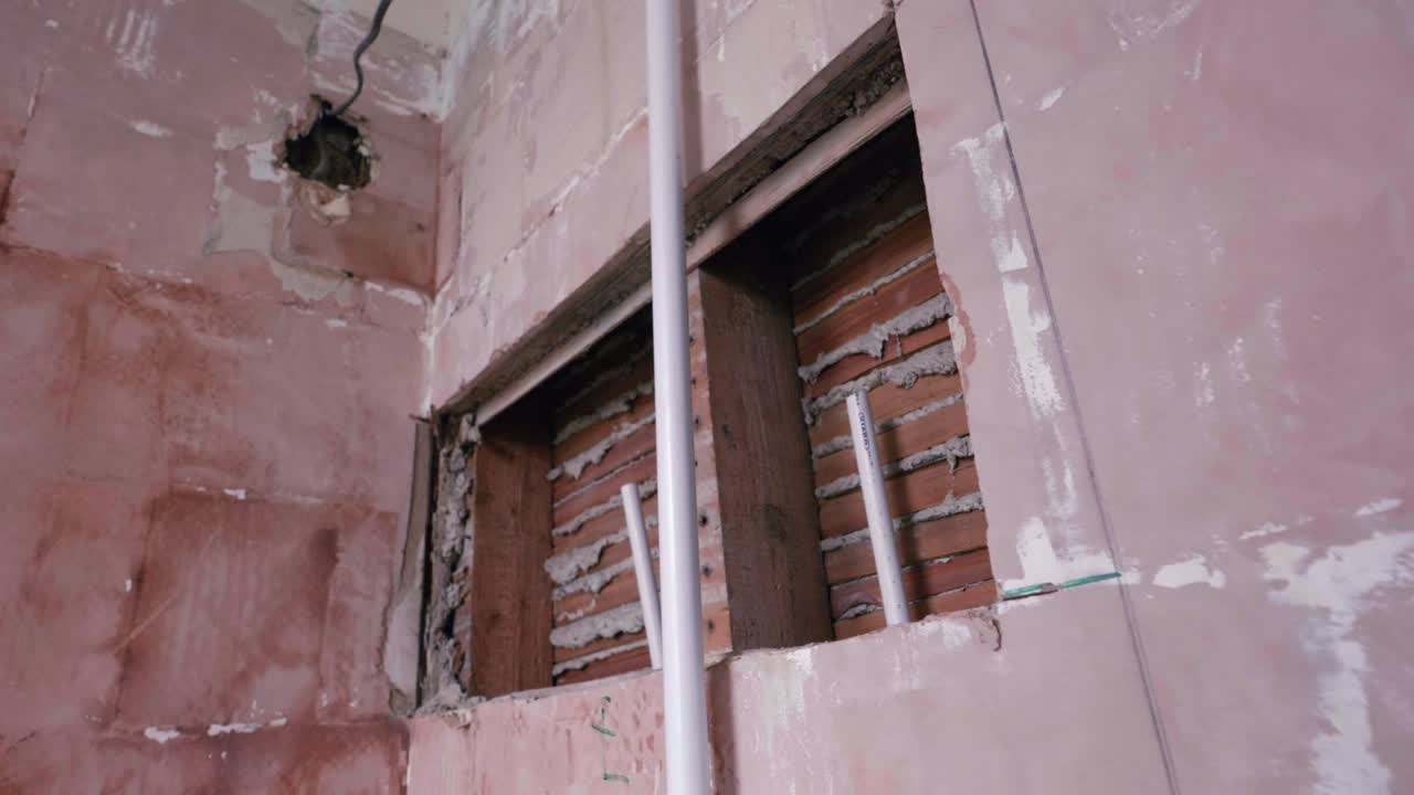 Bathroom renovation; orbit around hole in wall for shower installation. daylight