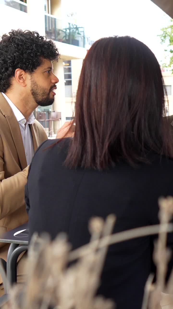 People at a table outdoors in an urban setting