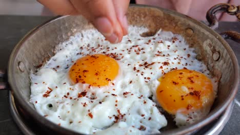 preparando huevos fritos en una sartén