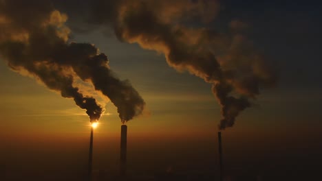 emisiones de la planta de energía vistas sobre la ciudad durante el amanecer