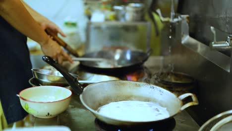 chef skillfully cooks with wok in kitchen