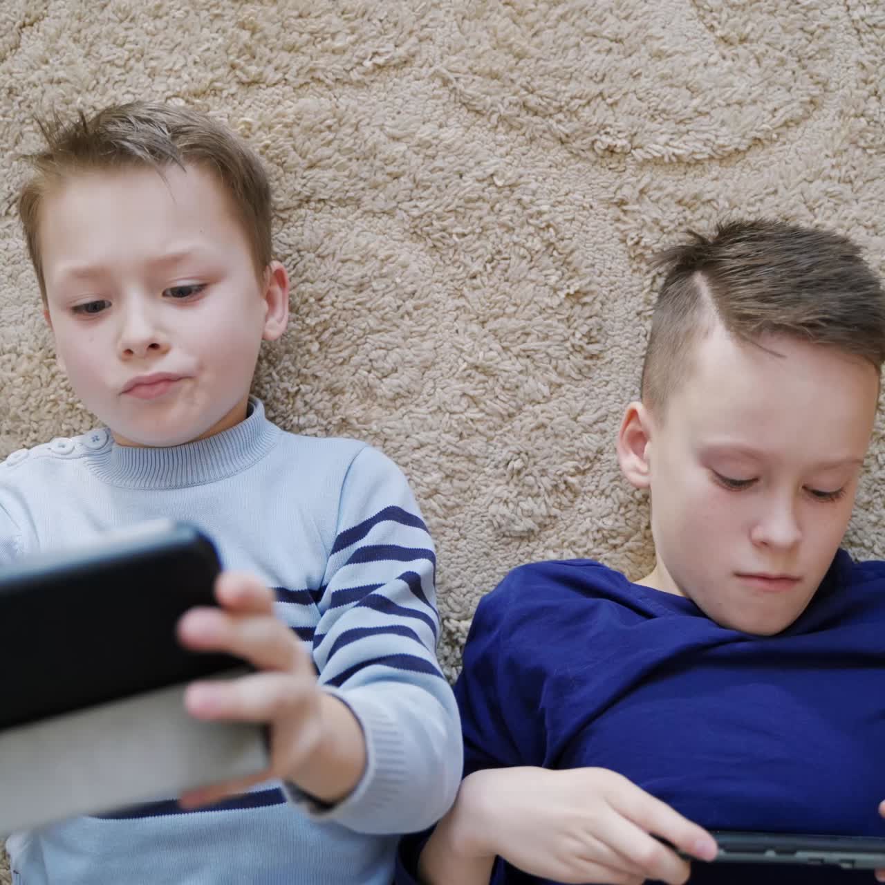 Boys using mobile gadgets at home