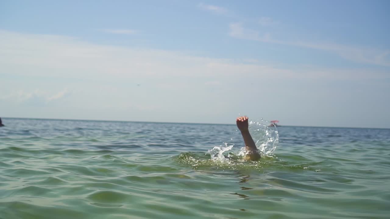 las manos de un hombre ahogándose en el mar 03