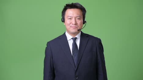 녹색 배경에 성숙한 일본 사업가