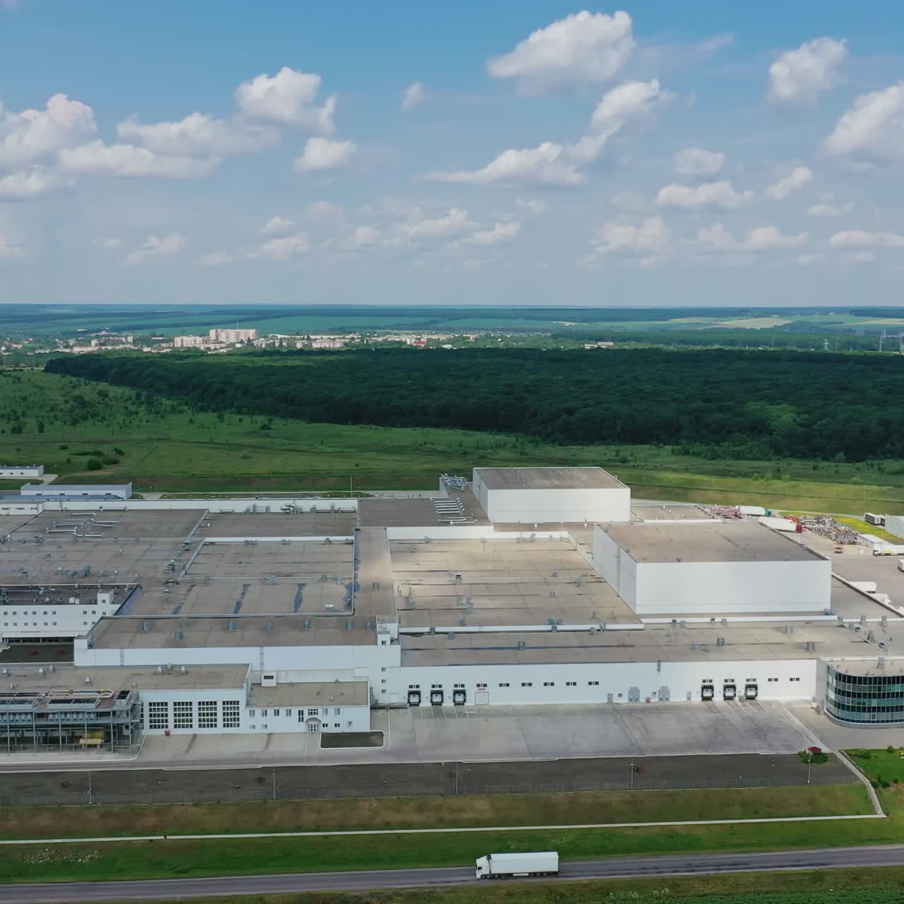 Panoramic view of industrial zone on fields. Large territory of modern factory on green nature background in the countryside. Aerial view.