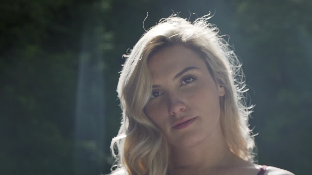 강한 젊은 여성이 카메라를 바라보고 슬로우 모션으로 돌아서다