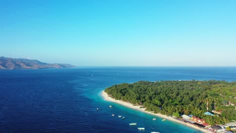 Isla-Tropical-Con-Vegetación-Verde,-Playa-De-Arena-Blanca-Bañada-Por-Mar-Azul,-Cielo-Brillante-En-Indonesia