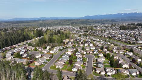 panning aerial revealing a multitude of houses living beneath mt