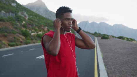 Hombre-Afroamericano-Usando-Auriculares-Mientras-Está-De-Pie-En-La-Carretera