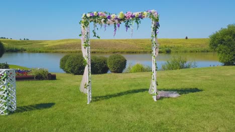 wedding arch with fresh flowers on green lawn close view