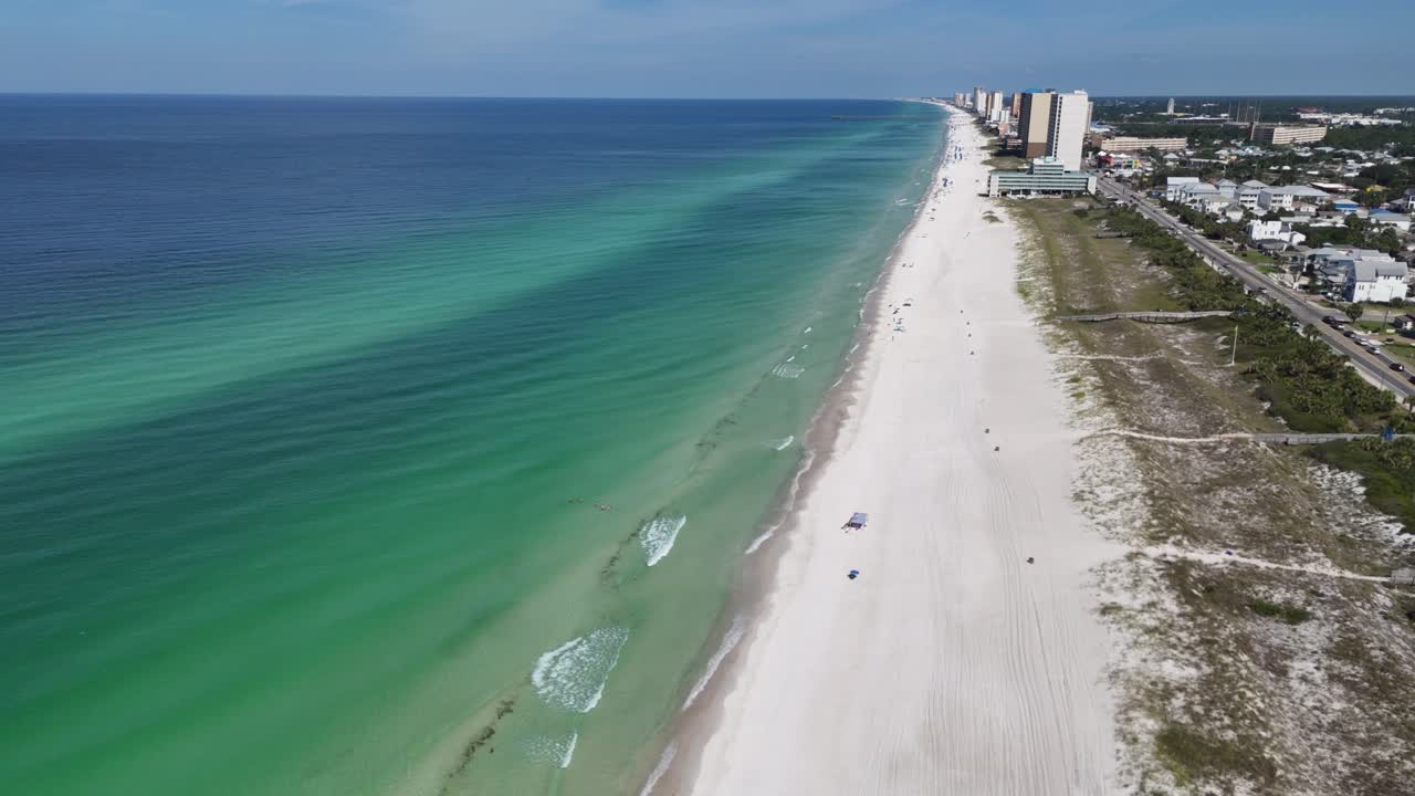 Panoramic drone movement over the white sandy beach and gentle waves along the turquoise sea, Panama City Beach, Florida, USA